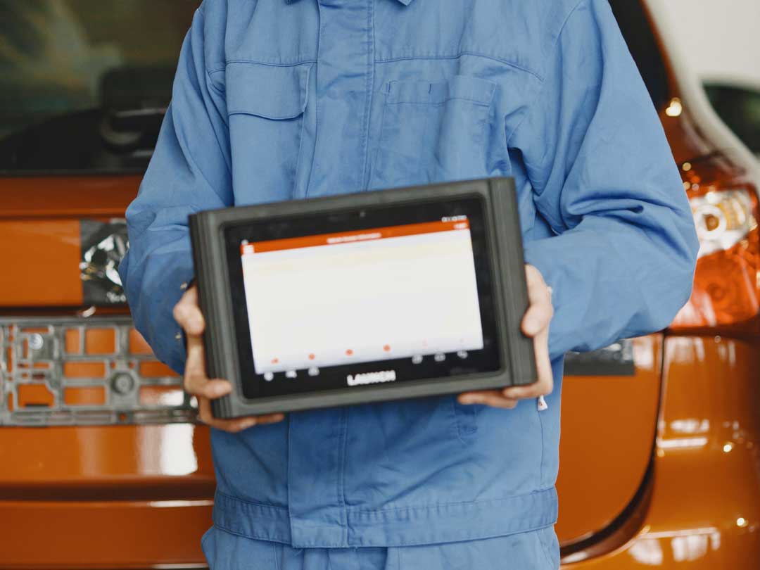 A man holding a car diagnostic screen