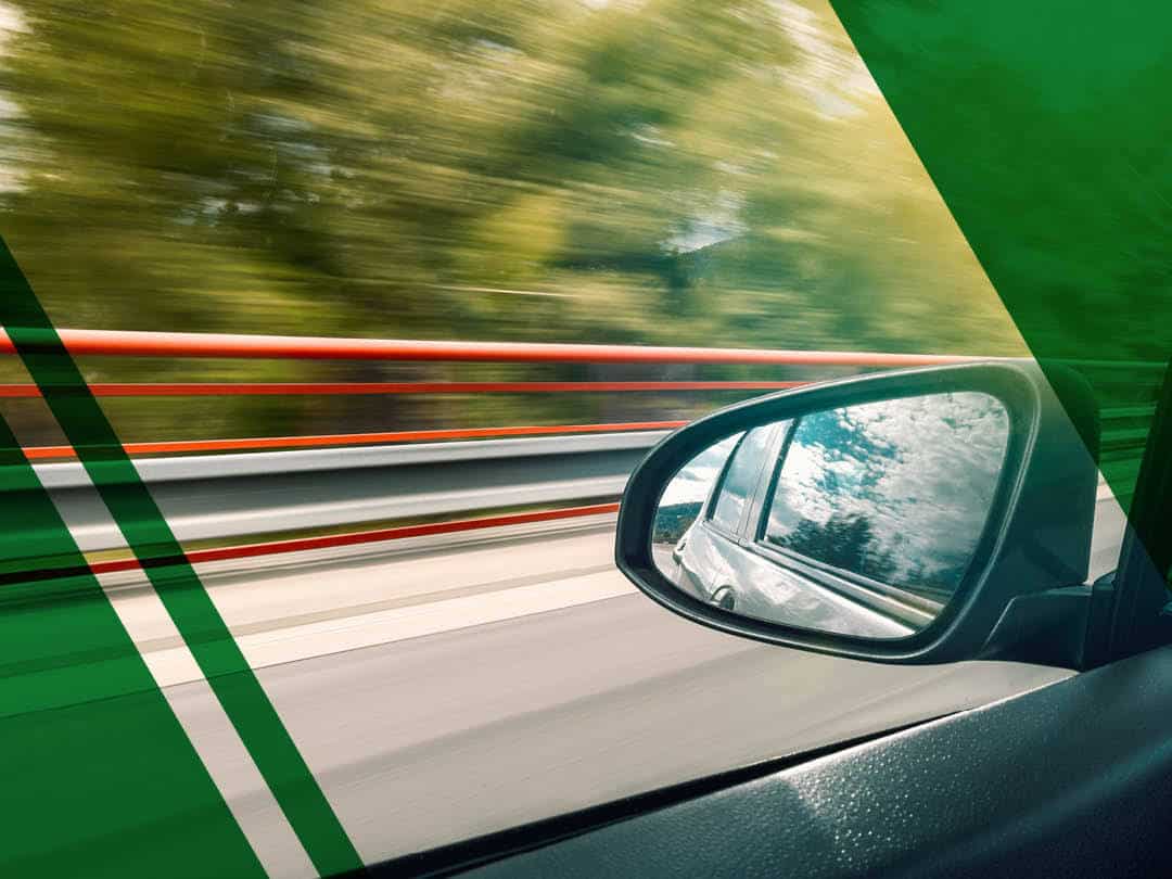 Wing mirror of car travelling fast, ADAS can reduce road traffic collisions.