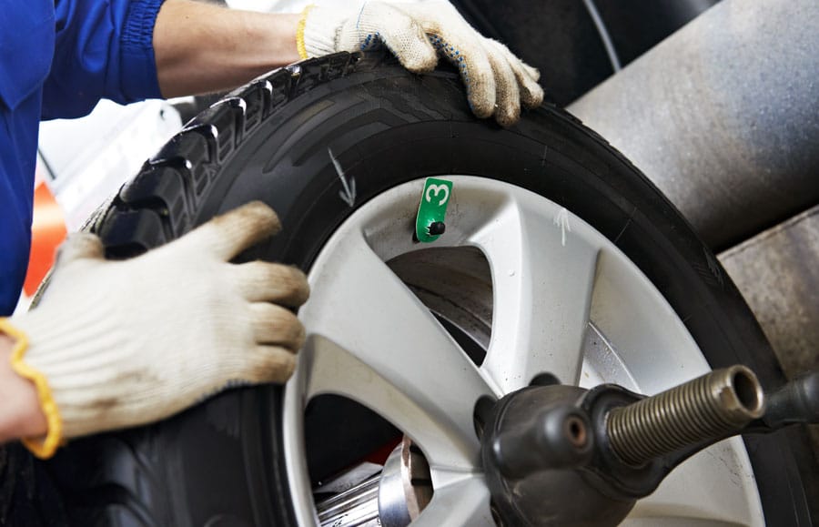 Mechanic working on car wheel alignment
