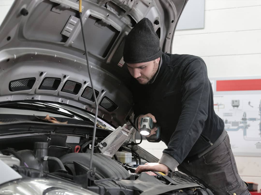Man inspecting car engine during a car service