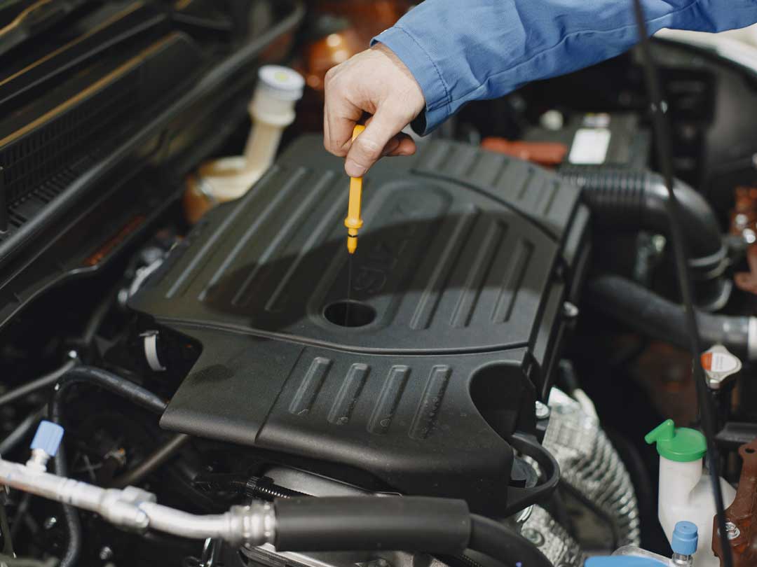 A mechanic checking the oil level of engine