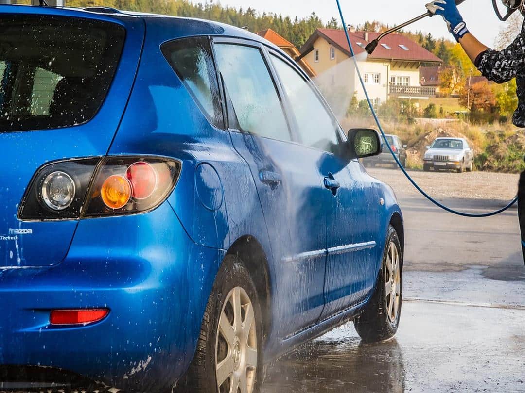 A blue car being put through car wash to protect paintwork